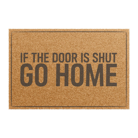 Top view of the If the Door Is Shut Go Home coir doormat, a small line of dark lettering above huge GO HOME inside a thin double border