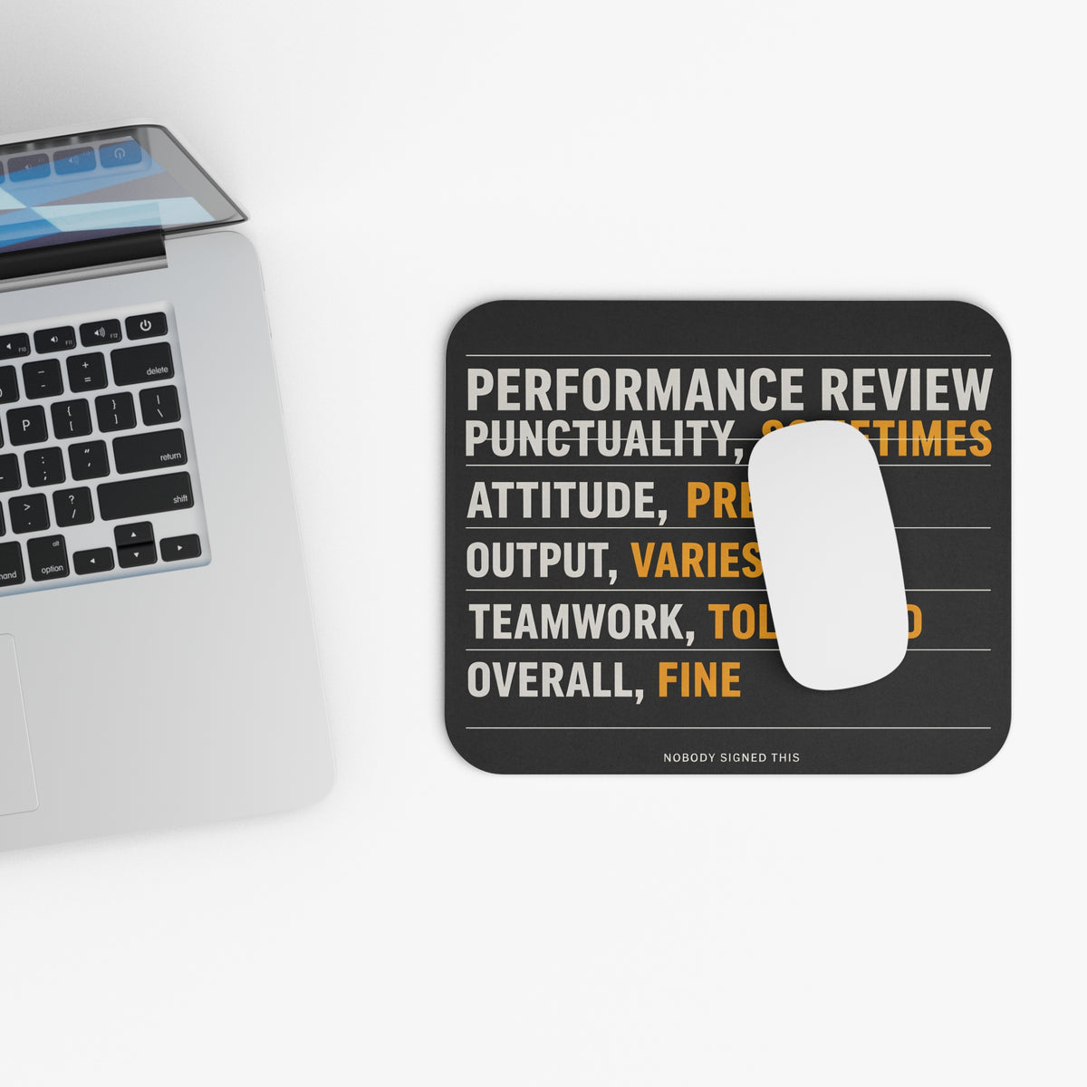 Top view of the performance review mouse pad beside a laptop keyboard