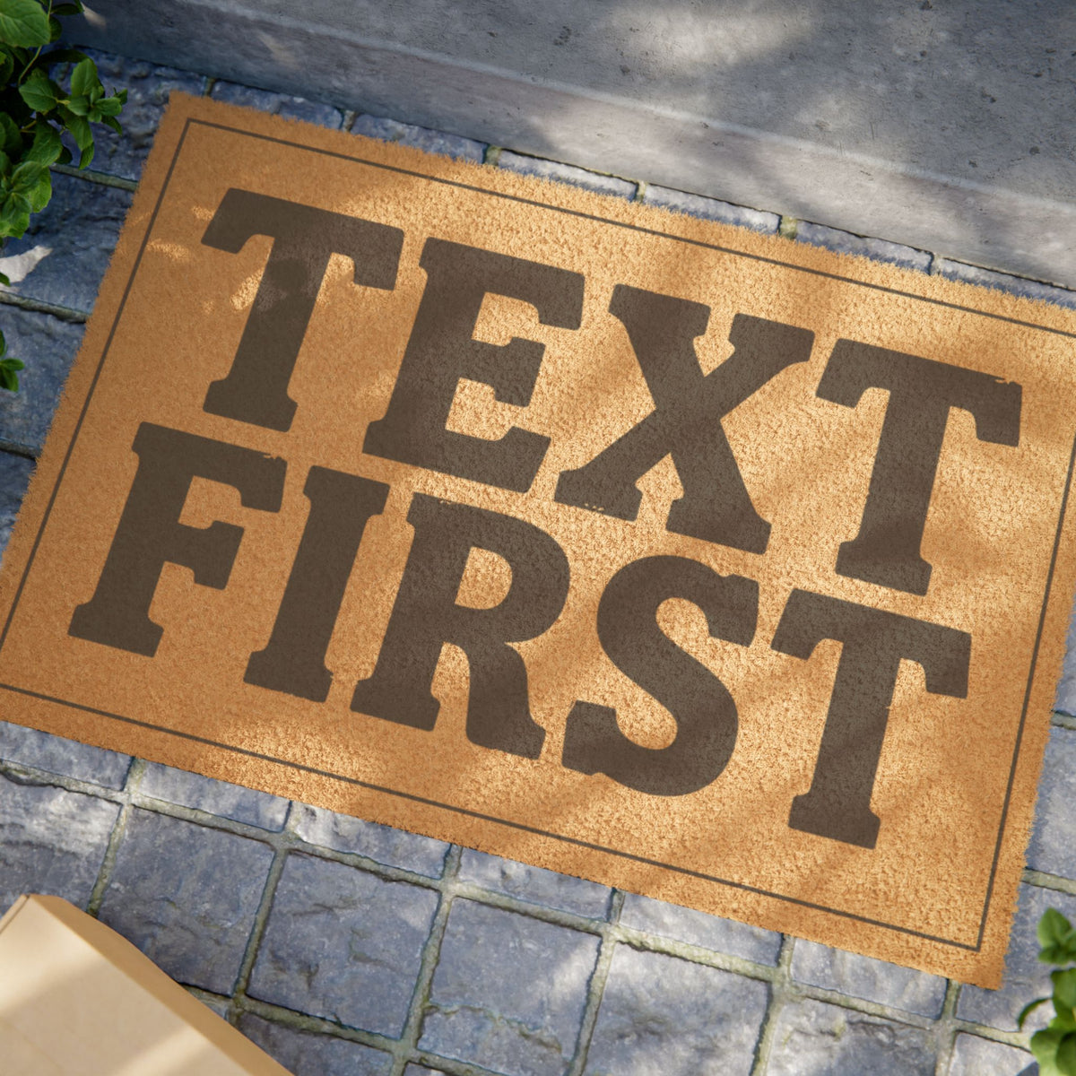 Close view of the Text First coir doormat on a stone patio in dappled sunlight
