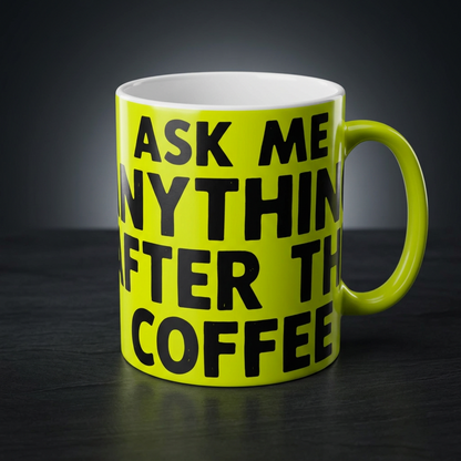 Funny coffee mug printed with "ASK ME ANYTHING AFTER THE COFFEE", shown on a dark studio background