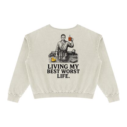 Khaki Green raw edge crewneck sweatshirt with a vintage illustration of a smiling man in a bathrobe raising a mug in a flooded room beside a rubber duck above bold Living my best worst life text on the front
