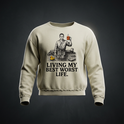 Khaki raw edge crewneck sweatshirt with a vintage illustration of a smiling man in a bathrobe raising a mug in a flooded room beside a rubber duck above bold Living my best worst life text on the front shown against a dark studio backdrop