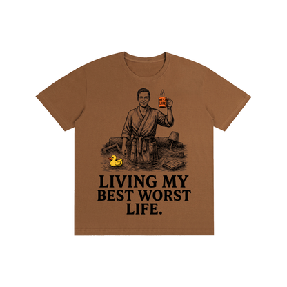 Caramel Macchiato cotton crewneck t-shirt with a vintage illustration of a smiling man in a bathrobe raising a mug in a flooded room beside a rubber duck above bold Living my best worst life text on the front