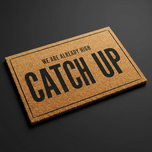 We Are Already High Catch Up coir doormat with dark lettering on natural tan coir, shown at an angle on a dark studio backdrop