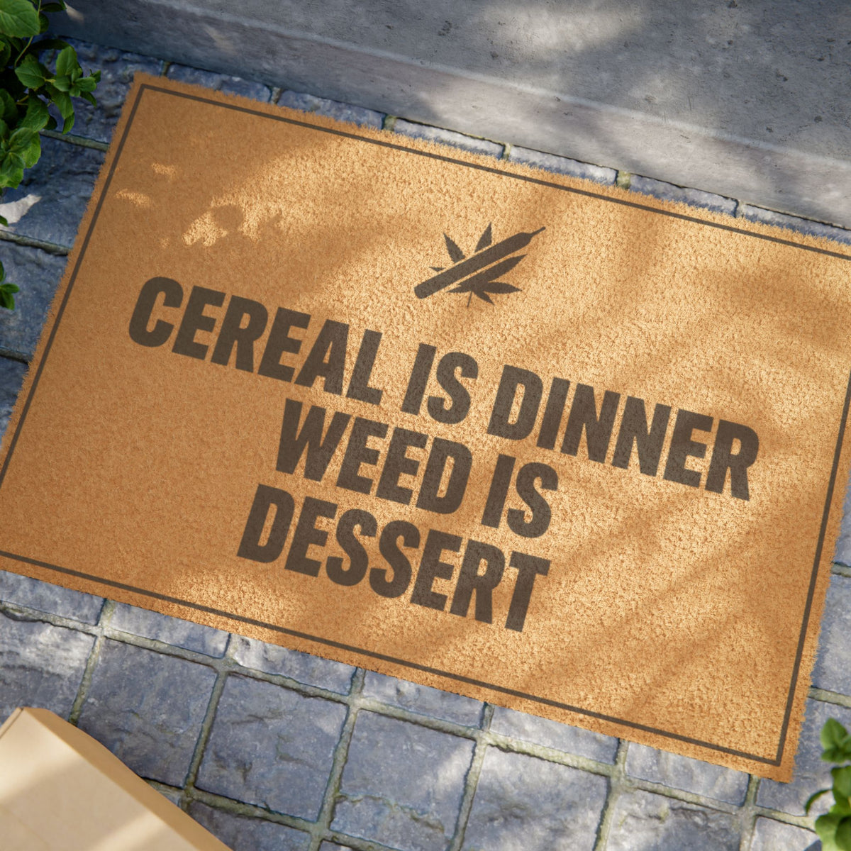 Close view of the Cereal Is Dinner Weed Is Dessert coir doormat on a stone patio in dappled sunlight