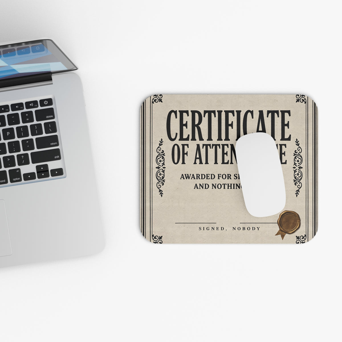 Top view of the certificate of attendance mouse pad beside a laptop keyboard