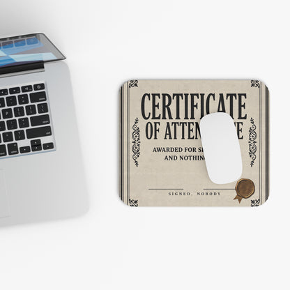 Top view of the certificate of attendance mouse pad beside a laptop keyboard