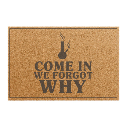 Top view of the Come In We Forgot Why coir doormat, dark lettering inside a thin border on natural tan fiber