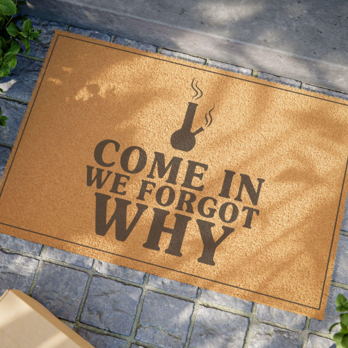 Close view of the Come In We Forgot Why Smoke Icon Layout coir doormat on a stone patio in dappled sunlight