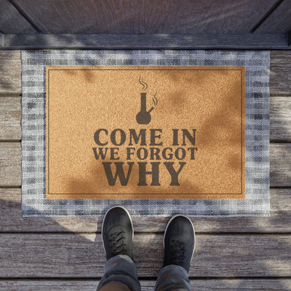 Come In We Forgot Why Smoke Icon Layout coir doormat on a wooden porch seen from above with a pair of shoes at the edge