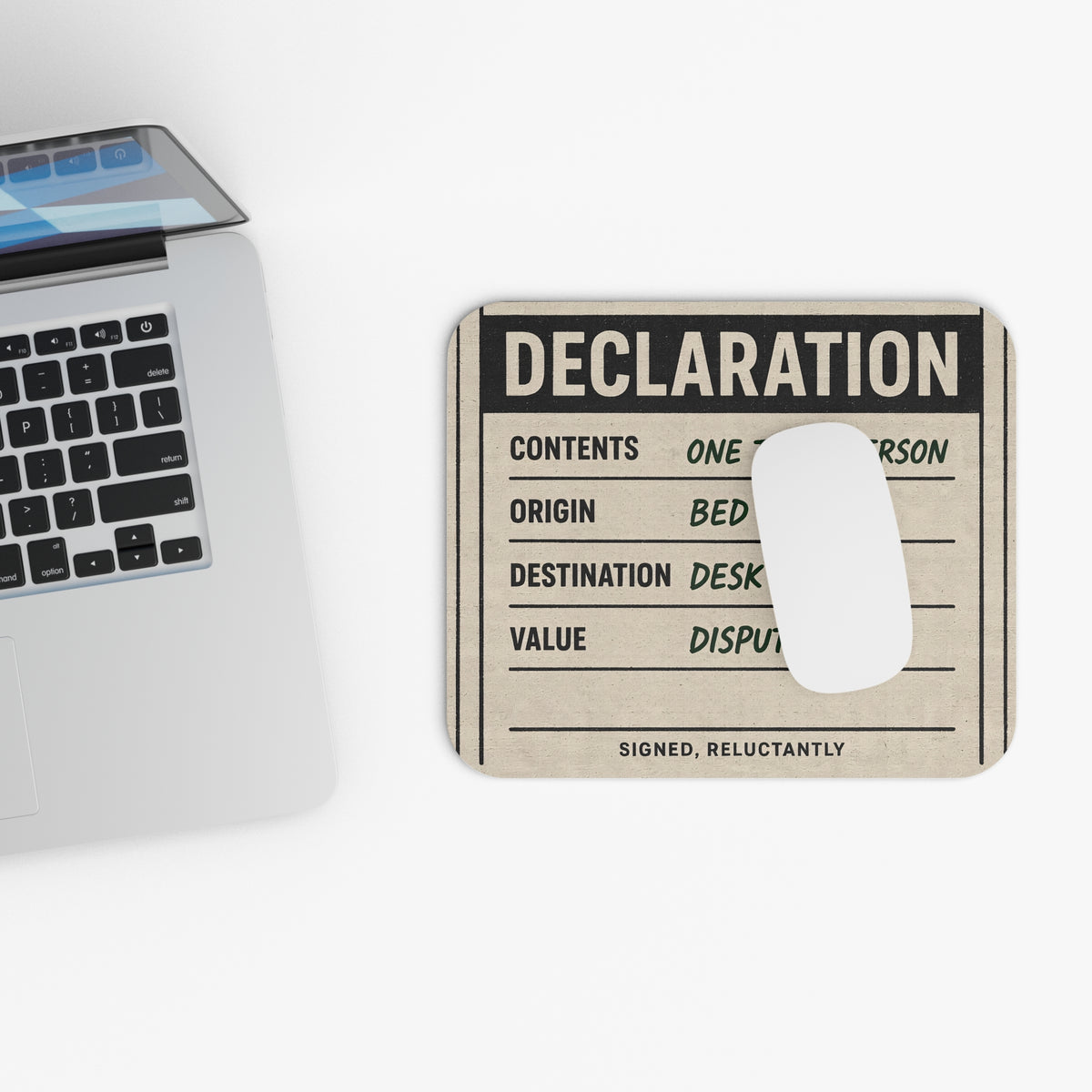 Top view of the declaration mouse pad beside a laptop keyboard
