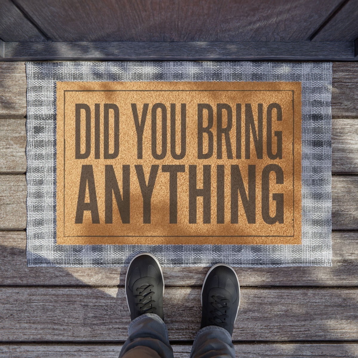 Did You Bring Anything coir doormat on a wooden porch seen from above with a pair of shoes at the edge