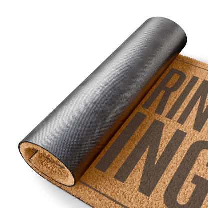 Rolled-up corner of the Did You Bring Anything coir doormat showing the black vinyl backing