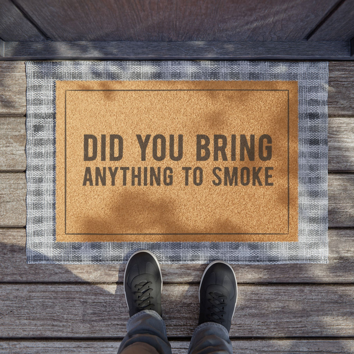 Did You Bring Anything to Smoke coir doormat on a wooden porch seen from above with a pair of shoes at the edge