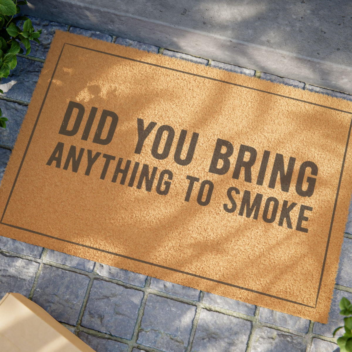 Close view of the Did You Bring Anything to Smoke coir doormat on a stone patio in dappled sunlight