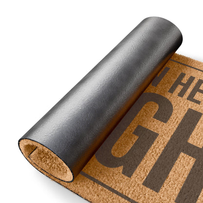 Rolled-up corner of the Everyone in Here Is High coir doormat showing the black vinyl backing