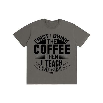 Charcoal Gray cotton crewneck t-shirt with black First I drink the coffee then I teach the kids lettering with a star ribbon banner on the front