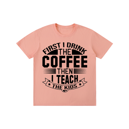 Pink cotton crewneck t-shirt with black First I drink the coffee then I teach the kids lettering with a star ribbon banner on the front