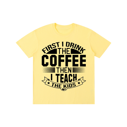 Yellow cotton crewneck t-shirt with black First I drink the coffee then I teach the kids lettering with a star ribbon banner on the front