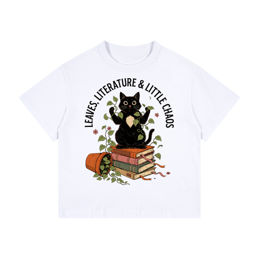 Kids’ loose-fit drop-shoulder tee with a black cat on books beside a tipped plant pot, Leaves, Literature & Little Chaos front print