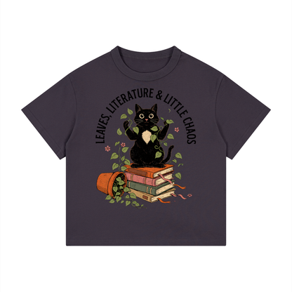 Kids’ loose-fit drop-shoulder tee with a black cat on books beside a tipped plant pot, Leaves, Literature & Little Chaos front print