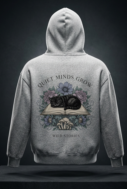 Kids’ fleece hoodie with a sleeping black cat on an open book among flowers, Quiet Minds Grow, Wild Stories back print