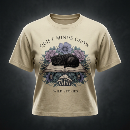 Kids’ loose-fit drop-shoulder tee with a sleeping black cat on an open book among flowers, Quiet Minds Grow, Wild Stories front print