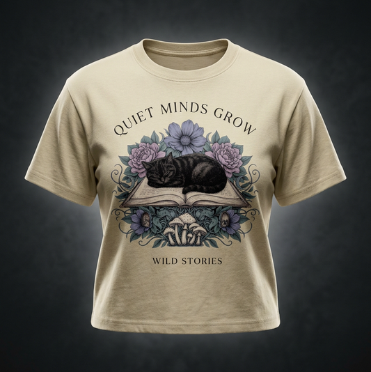 Kids’ loose-fit drop-shoulder tee with a sleeping black cat on an open book among flowers, Quiet Minds Grow, Wild Stories front print
