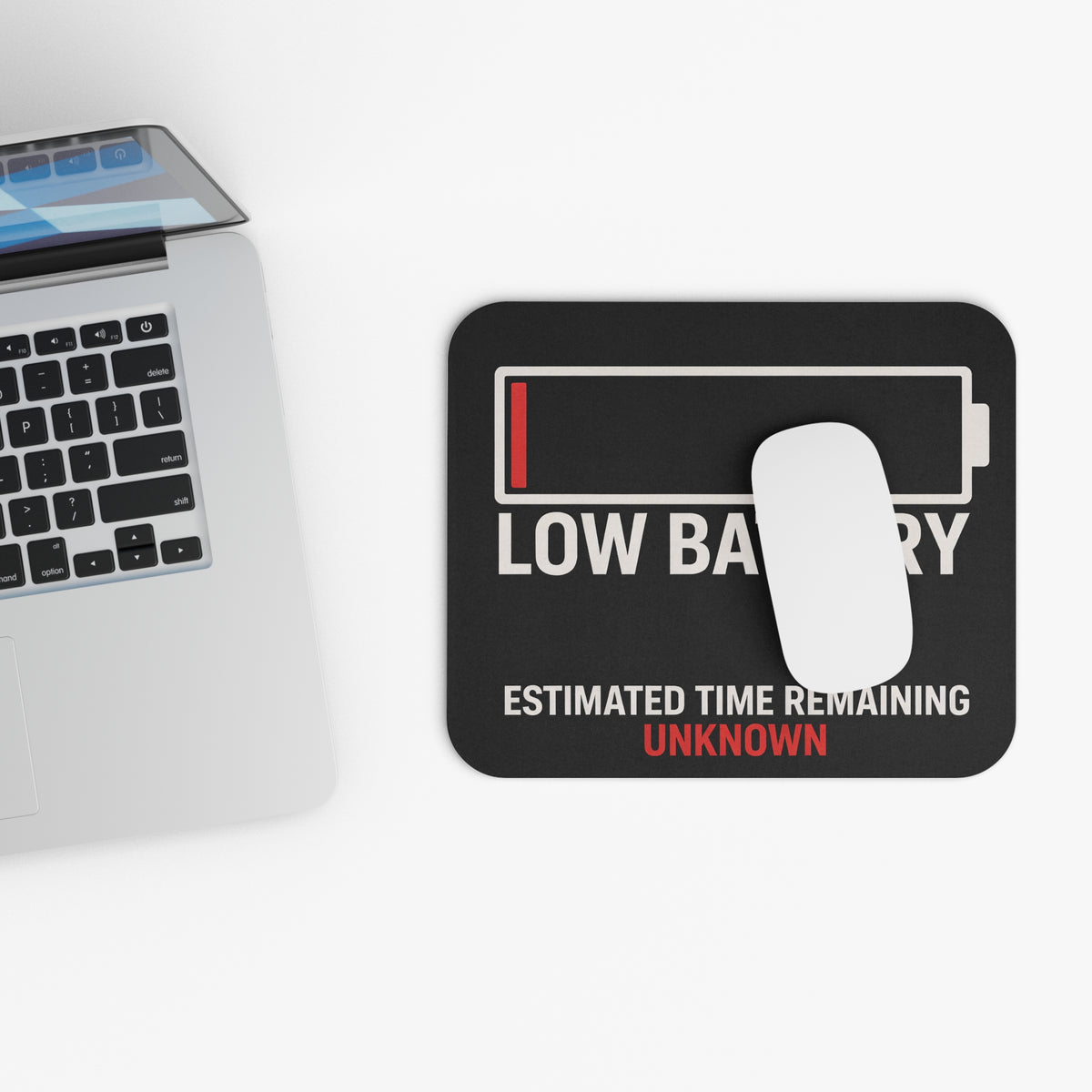 Top view of the low battery mouse pad beside a laptop keyboard