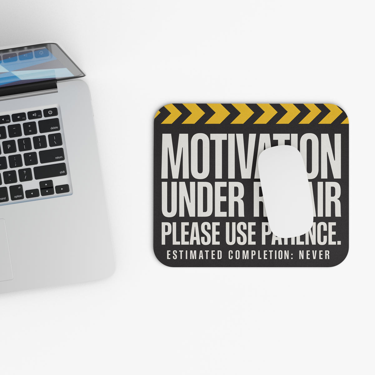 Top view of the motivation under repair mouse pad beside a laptop keyboard