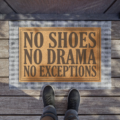 No Shoes No Drama No Exceptions coir doormat on a wooden porch seen from above with a pair of shoes at the edge