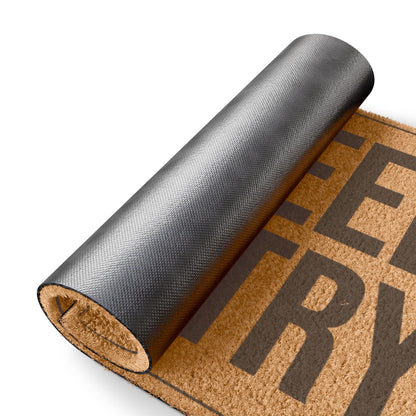 Rolled-up corner of the No Weed No Entry coir doormat showing the black vinyl backing