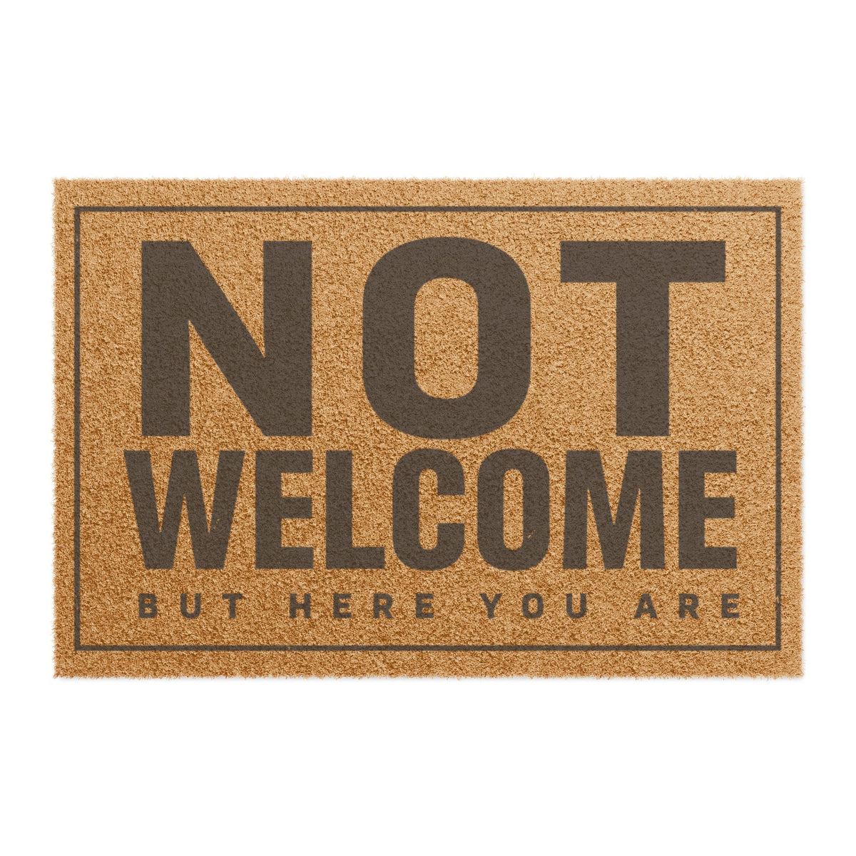 Top view of the Not Welcome But Here You Are coir doormat, dark lettering inside a thin border on natural tan fiber