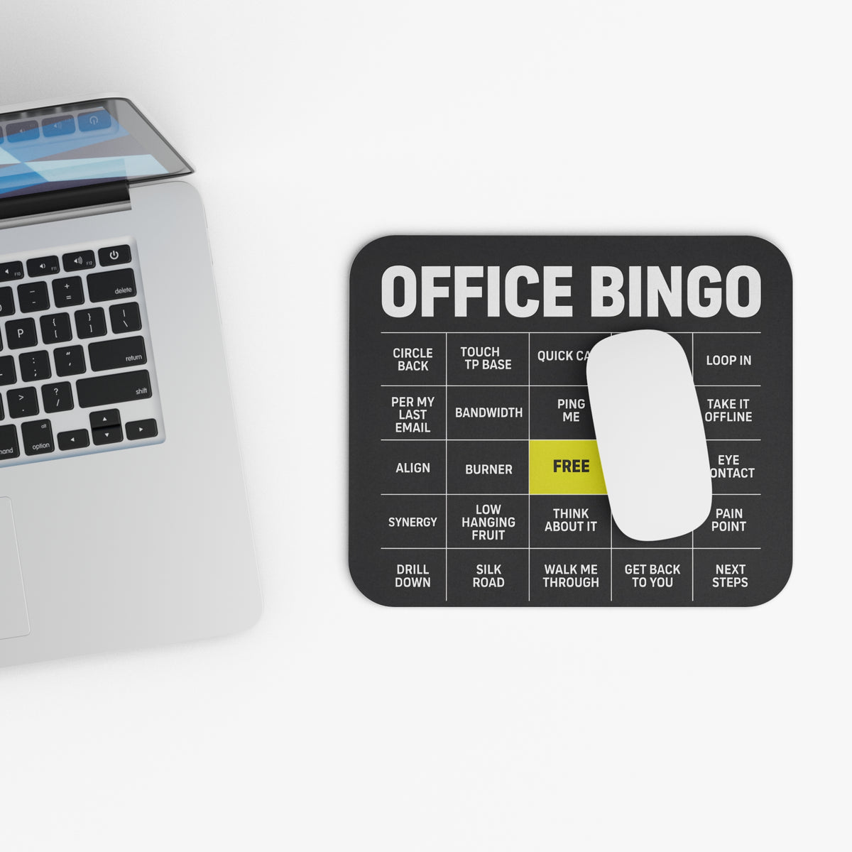 Top view of the office bingo mouse pad beside a laptop keyboard