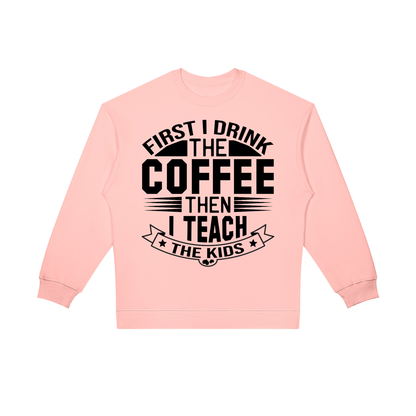 Pink oversized crewneck sweatshirt with black First I drink the coffee then I teach the kids lettering with a star ribbon banner on the front