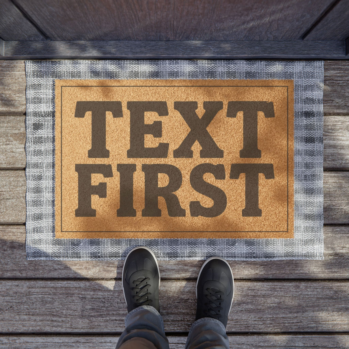 Text First coir doormat on a wooden porch seen from above with a pair of shoes at the edge