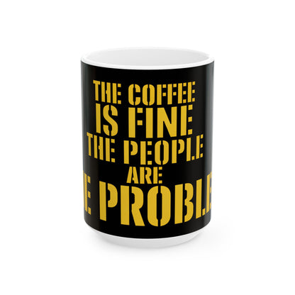 Funny coffee mug printed with "THE COFFEE IS FINE THE PEOPLE ARE THE PROBLEM", three-quarter view with the handle on the right