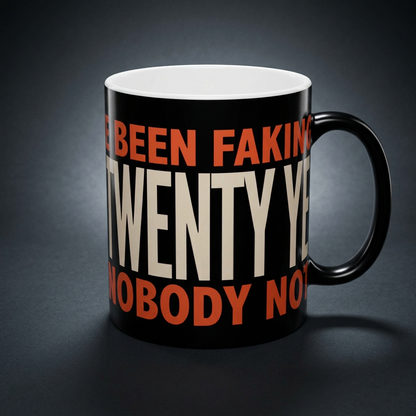 Funny coffee mug printed with "I HAVE BEEN FAKING THIS FOR TWENTY YEARS AND NOBODY NOTICED", shown on a dark studio background