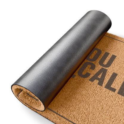 Rolled-up corner of the Were You Going to Call First coir doormat showing the black vinyl backing
