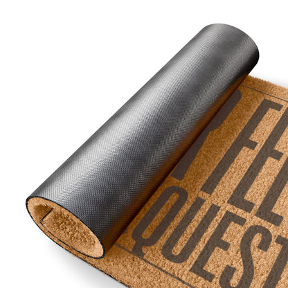 Rolled-up corner of the Wipe Your Feet It's Not a Request coir doormat showing the black vinyl backing