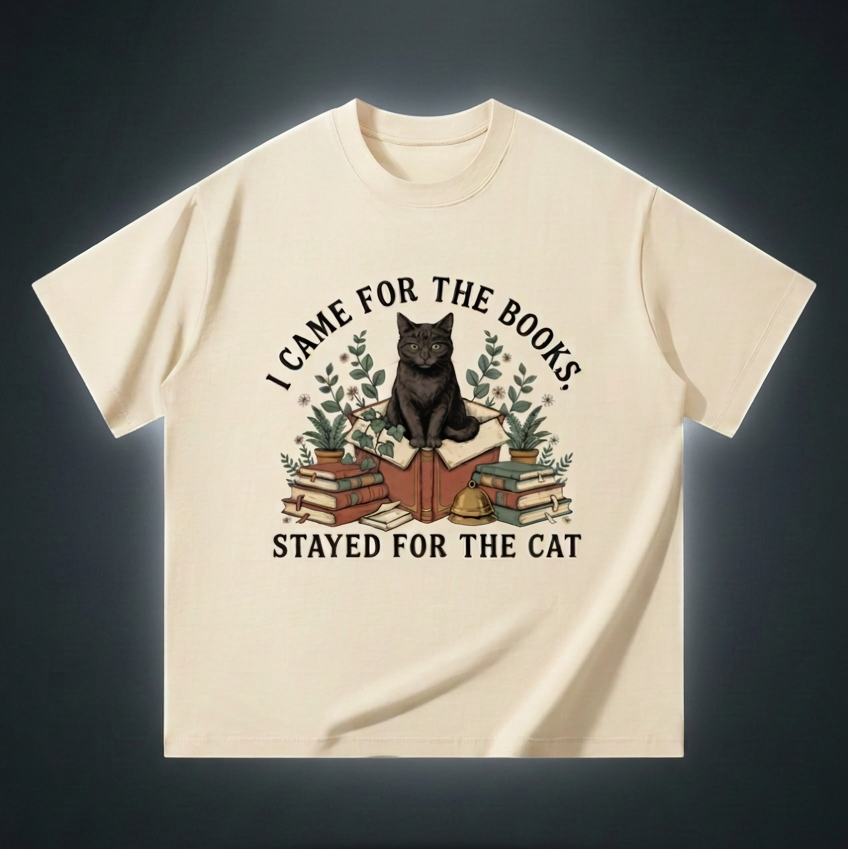 Unisex oversized heavyweight cotton tee with a black cat on a stack of books and plants, I Came for the Books, Stayed for the Cat front print