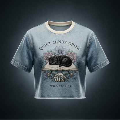 Unisex vintage-wash boxy tee with a raw hem with a sleeping black cat on an open book among flowers, Quiet Minds Grow, Wild Stories front print