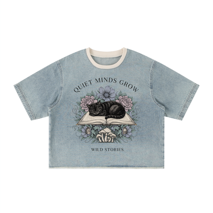 Unisex vintage-wash boxy tee with a raw hem with a sleeping black cat on an open book among flowers, Quiet Minds Grow, Wild Stories front print