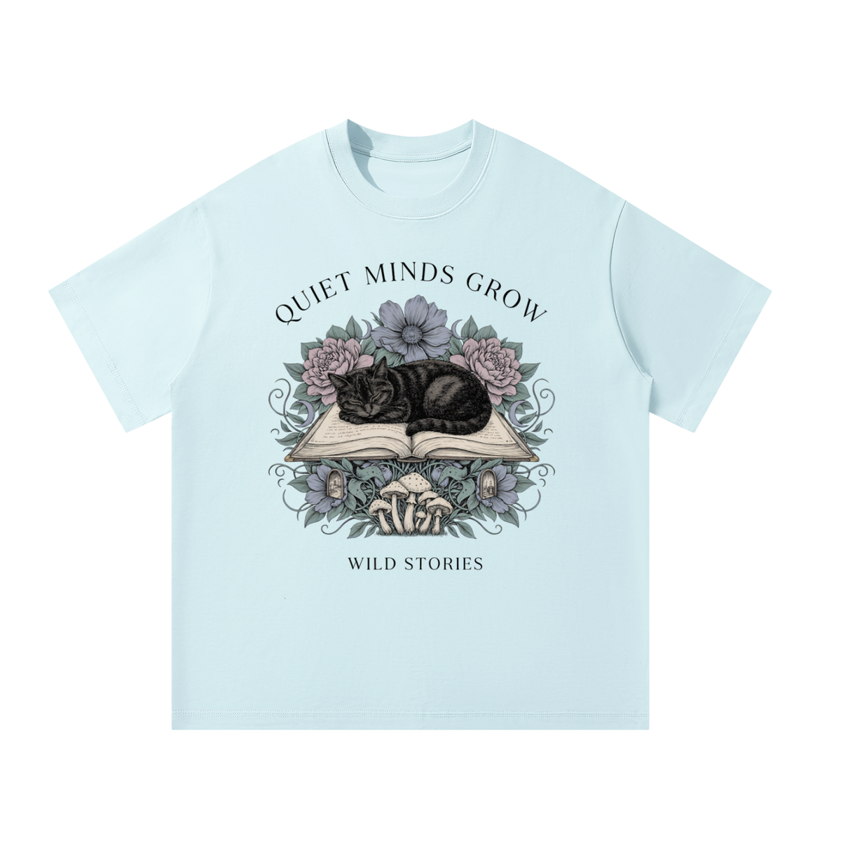 Unisex oversized heavyweight cotton tee with a sleeping black cat on an open book among flowers, Quiet Minds Grow, Wild Stories front print