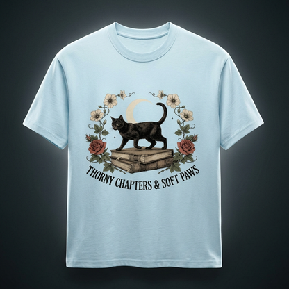 Unisex oversized heavyweight cotton tee with a black cat walking over old books under a crescent moon, Thorny Chapters & Soft Paws front print