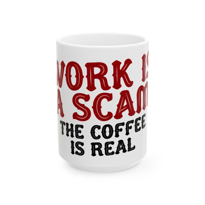 Funny coffee mug printed with "WORK IS A SCAM / THE COFFEE IS REAL", three-quarter view with the handle on the right