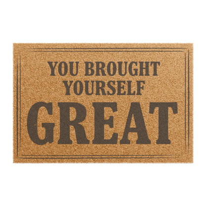 Top view of the You Brought Yourself Great coir doormat, dark lettering inside a thin border on natural tan fiber