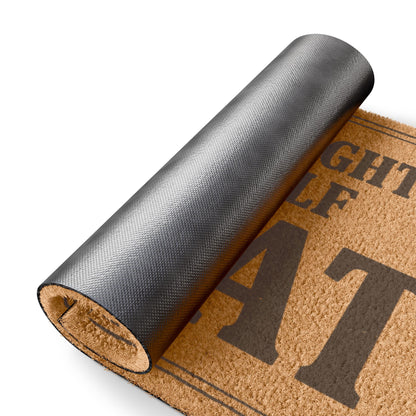 Rolled-up corner of the You Brought Yourself Great coir doormat showing the black vinyl backing