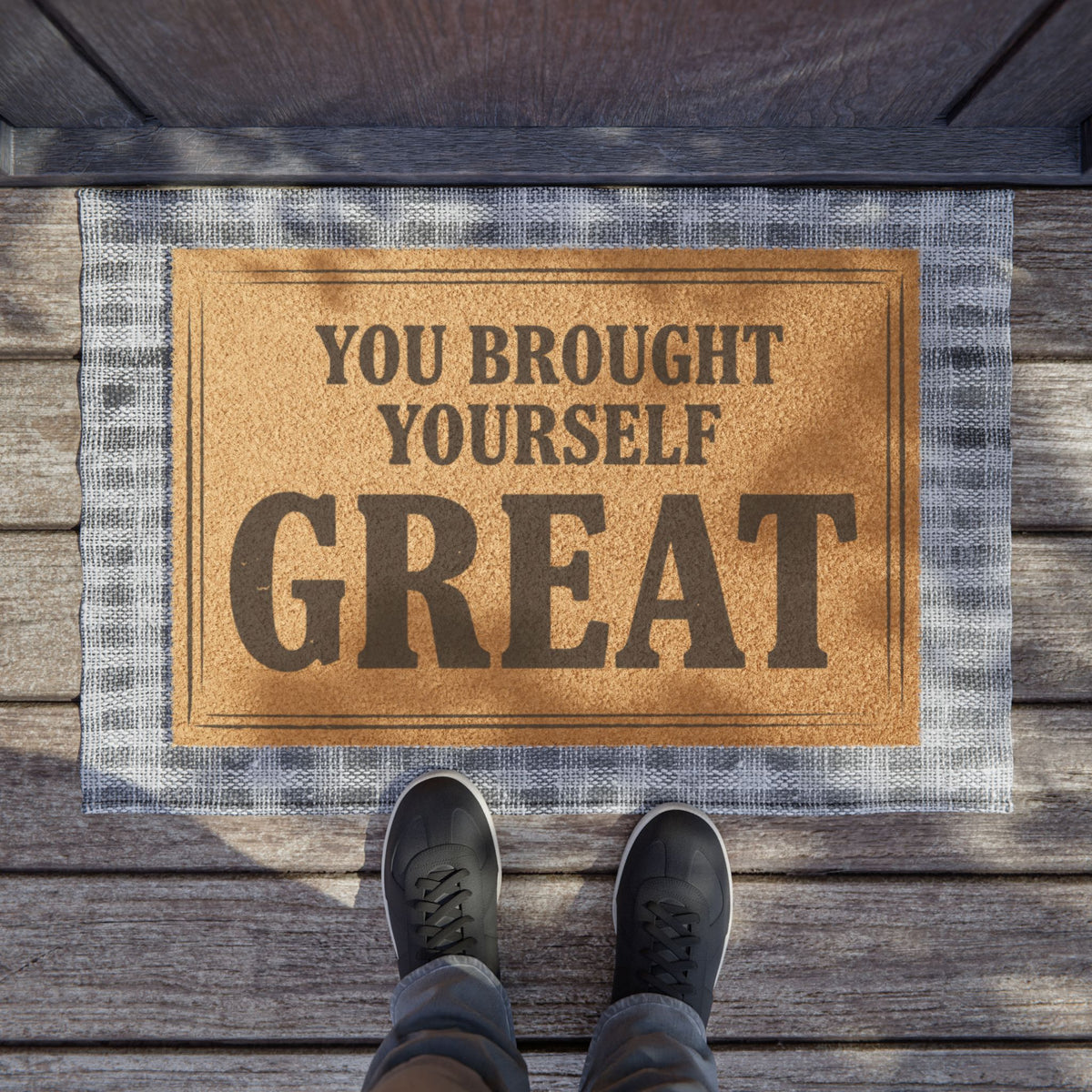 You Brought Yourself Great coir doormat on a wooden porch seen from above with a pair of shoes at the edge