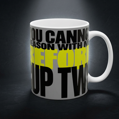 Funny coffee mug printed with "YOU CANNOT REASON WITH ME BEFORE CUP TWO", shown on a dark studio background